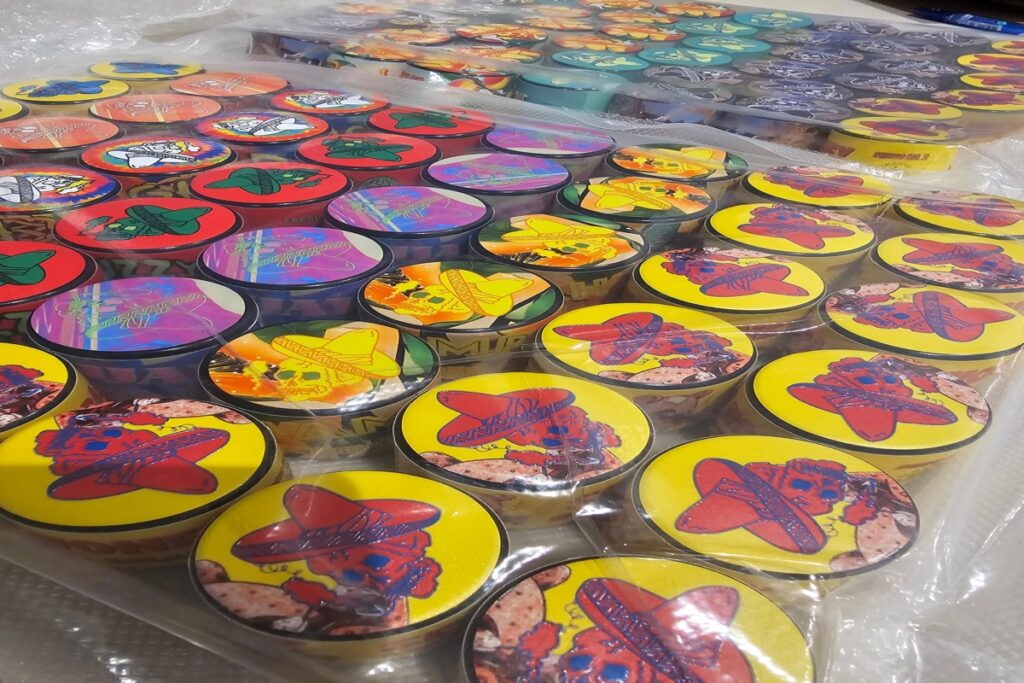 Bulk display of live rosin jars with colorful branded lids packaged for distribution