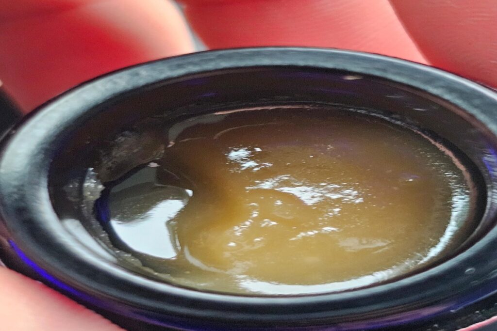 Close-up of live rosin cannabis concentrate inside jar showing terpene-rich sauce texture